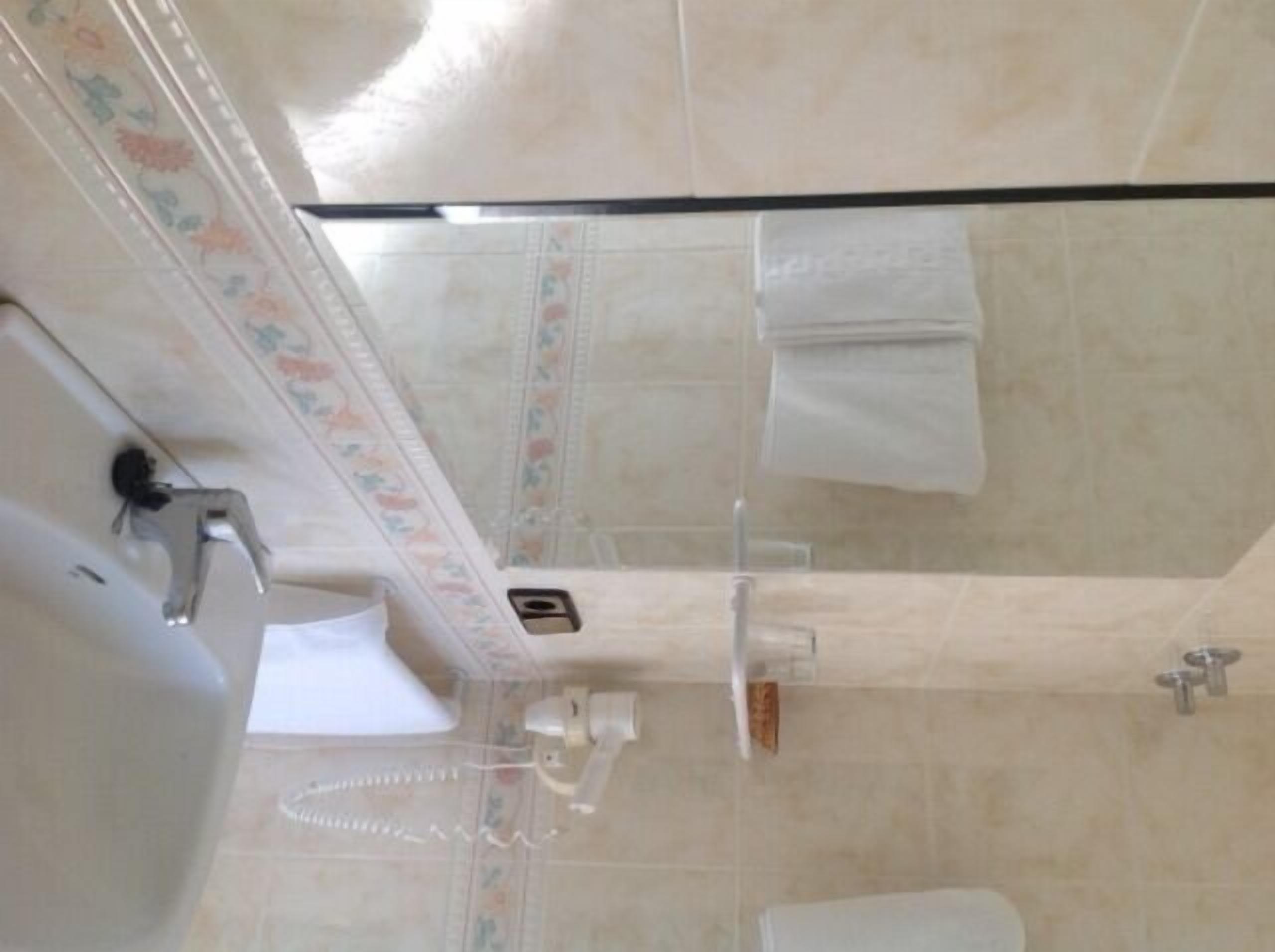 A bathroom with a toilet, sink, and shower area.