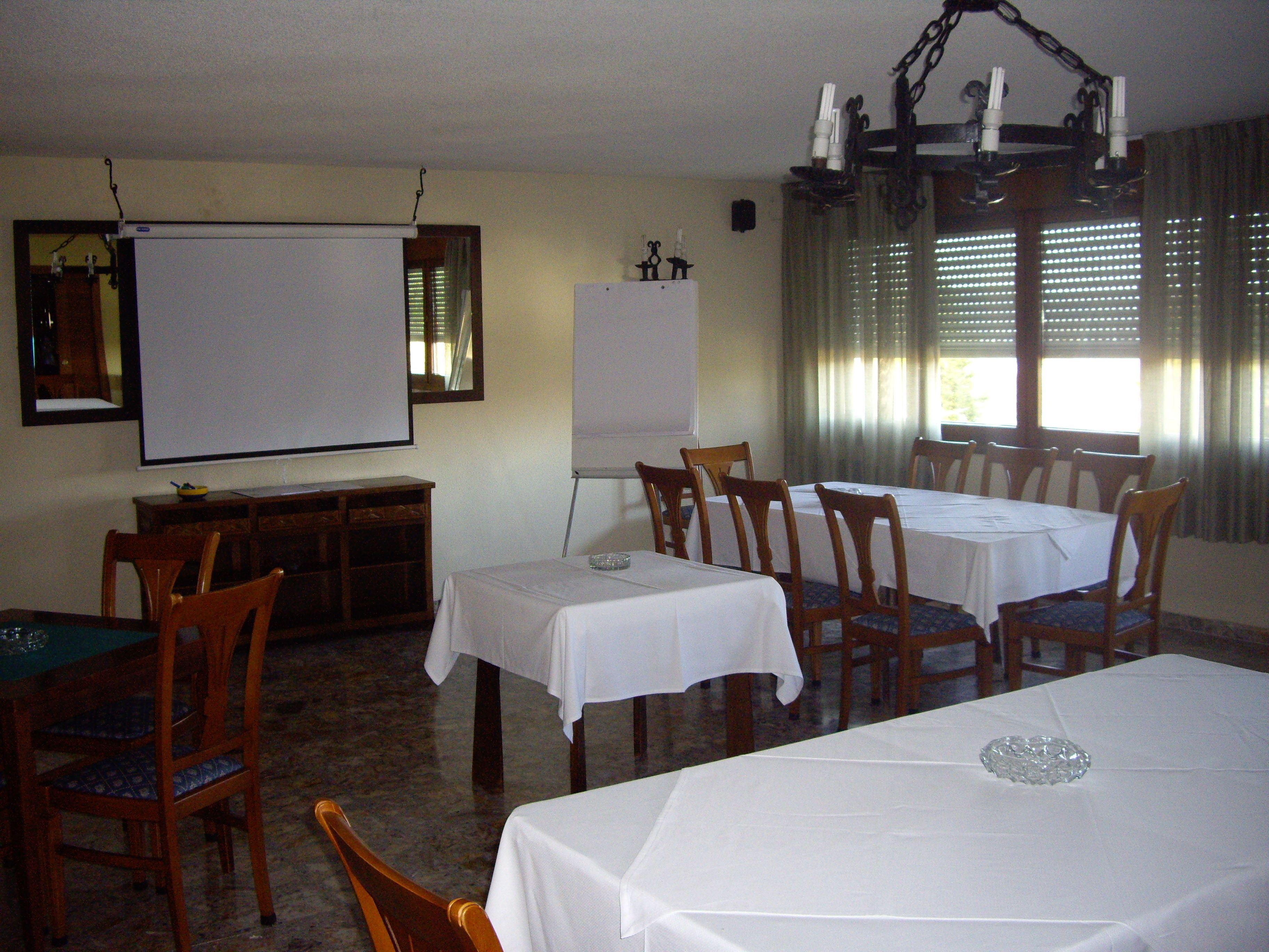 Une salle de conférence équipée d’un tableau blanc, de tables et de chaises.