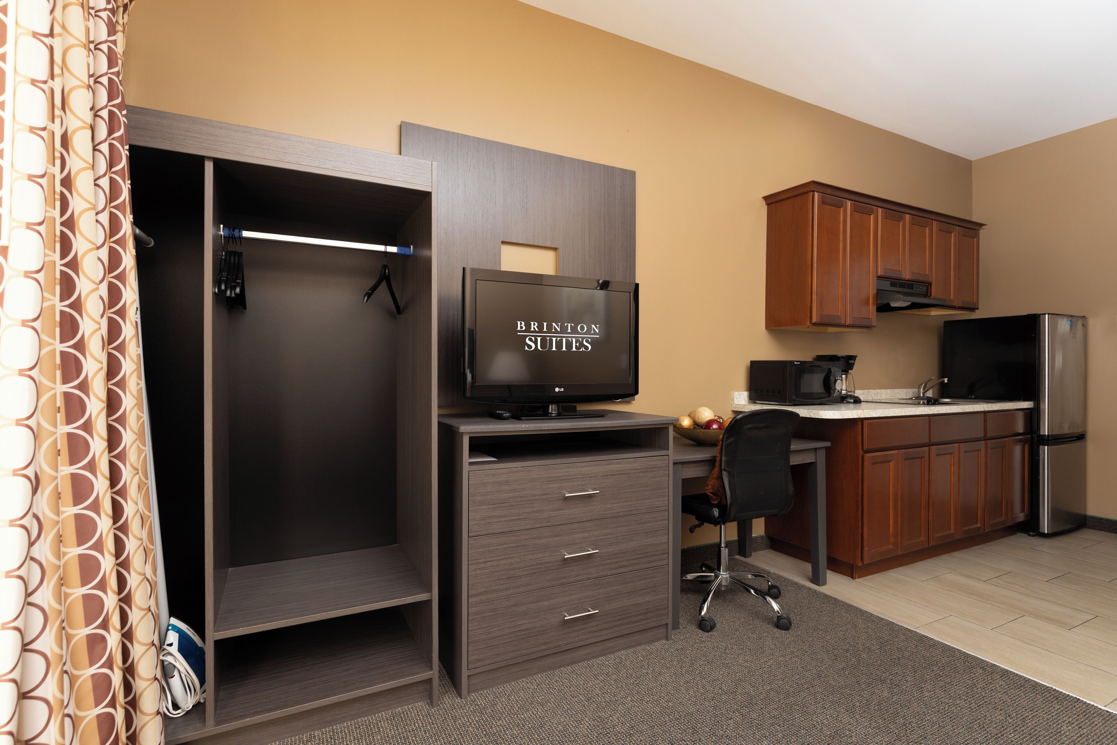 A compact kitchenette with a refrigerator, microwave, and coffee maker.