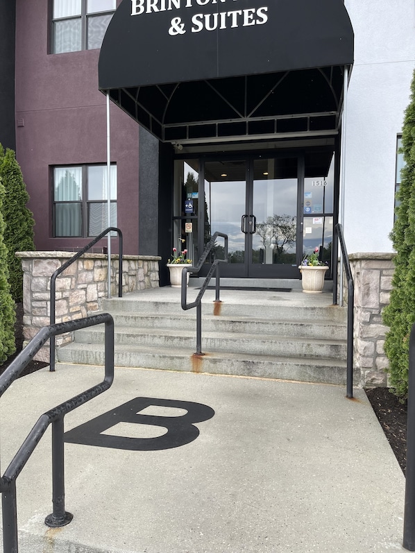A hotel entrance with a sign reading "BRINTON & SUITES".