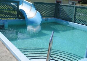 Ein Swimmingpool mit einer blauen Rutsche.