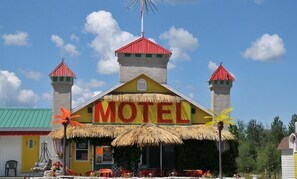 Ein farbenfrohes Gebäude mit einem Schild, das "Motel" zeigt, und zwei Türmen mit roten Dächern.