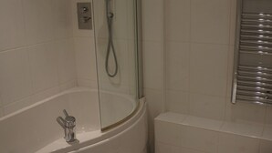 Een badkamer met een bad, een douche en een toilet.