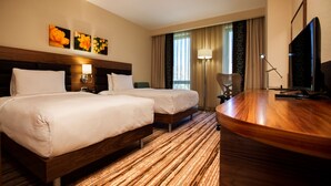 A hotel room with two beds, a desk, a TV, and a window with curtains. - Hilton Garden Inn Erzincan (Erzincan)