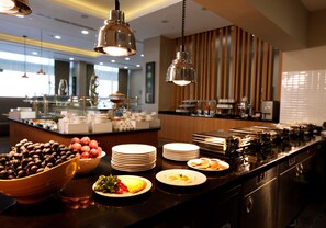 Disposição de buffet com diversos alimentos e pratos.