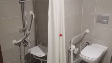 A bathroom with a shower, toilet, and a small bench.