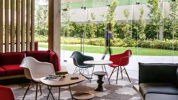 A modern indoor seating area with a view of a green courtyard and buildings. - ibis México Alameda (Mexico City)