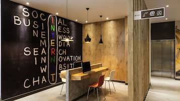 Una recepción con una computadora portátil, una pared de madera con texto y un letrero que indica los servicios.