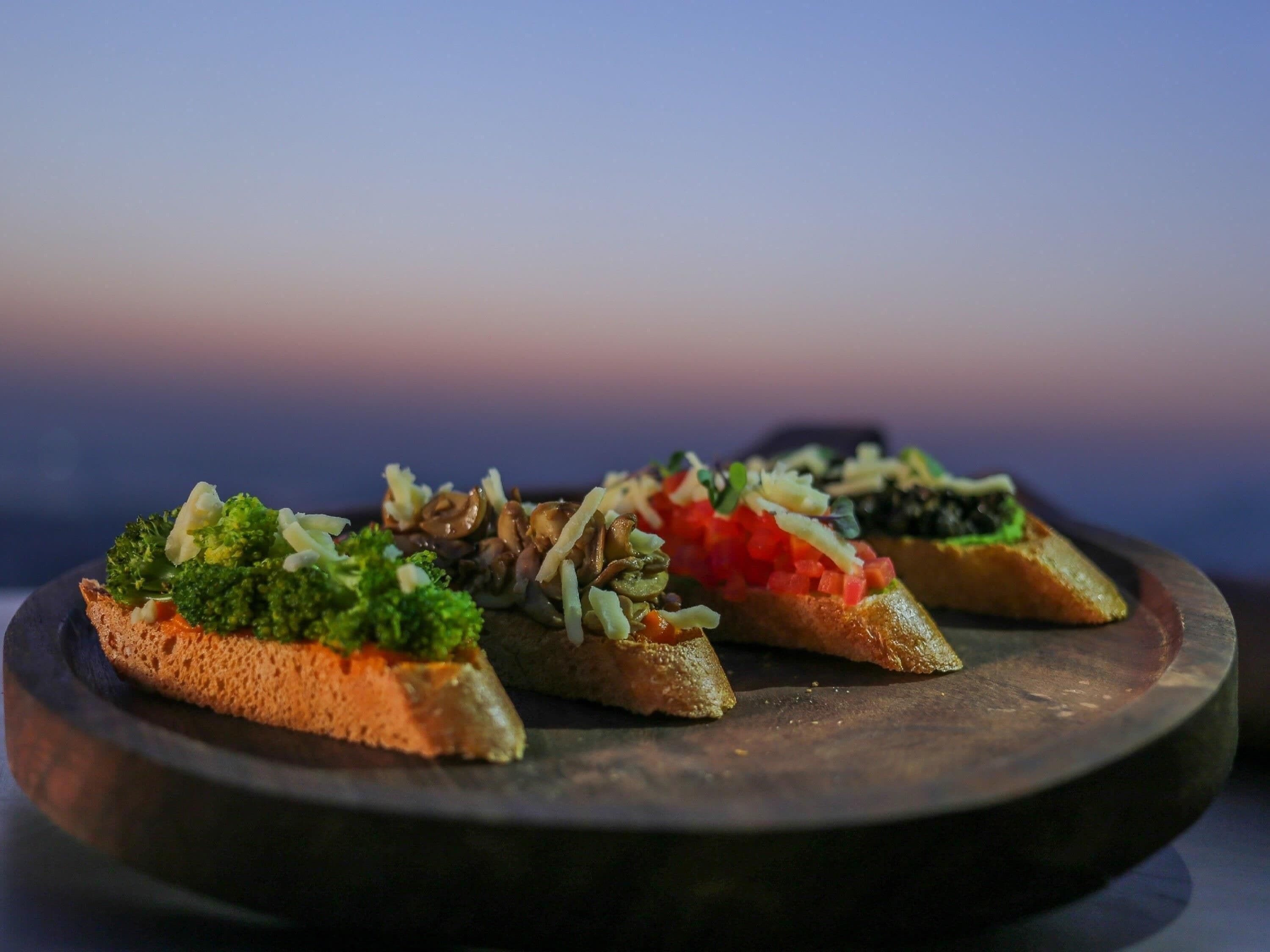Three pieces of bruschetta on a dark plate.