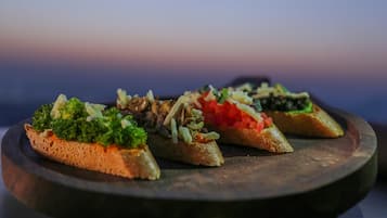 Three pieces of bruschetta on a dark plate.
