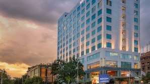 En høj, moderne hotels bygning med skilt, der viser 'Mercure Hotel'.
