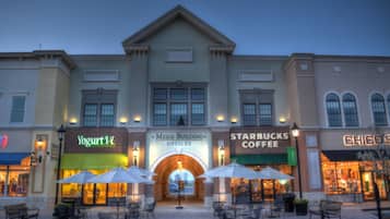 A building with multiple storefronts including Yogurt Vi, Meigs Building Offices, Starbucks Coffee, and Chico's.