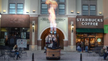 A building with a brick facade, a Starbucks Coffee sign, and a fire display in the center.