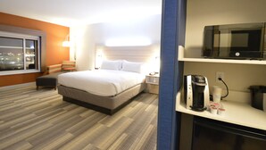 A hotel room with a bed, a coffee maker, a microwave, and a window with a city view. - Holiday Inn Express & Suites Toledo South - Perrysburg by IHG (Perrysburg)