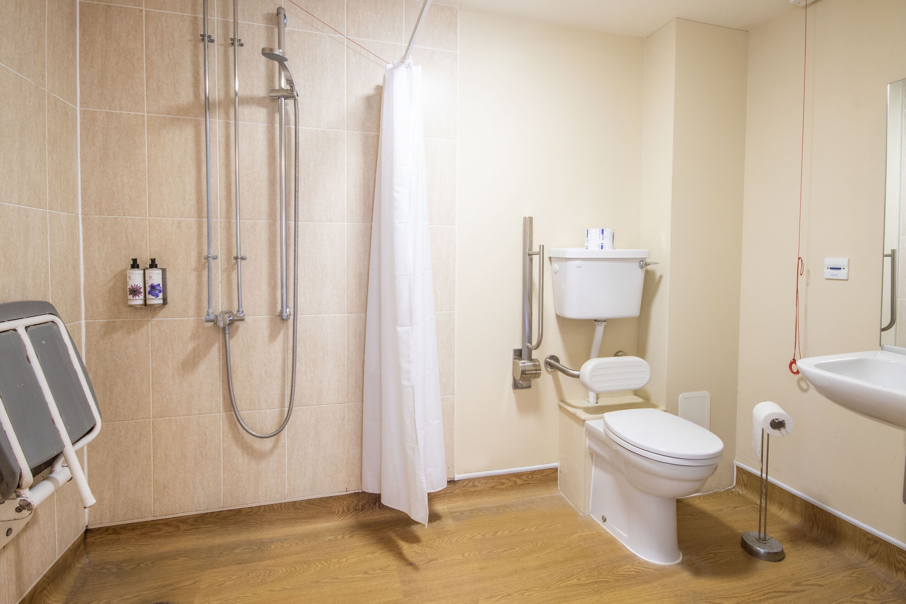 A modern bathroom with a shower, toilet, and sink.