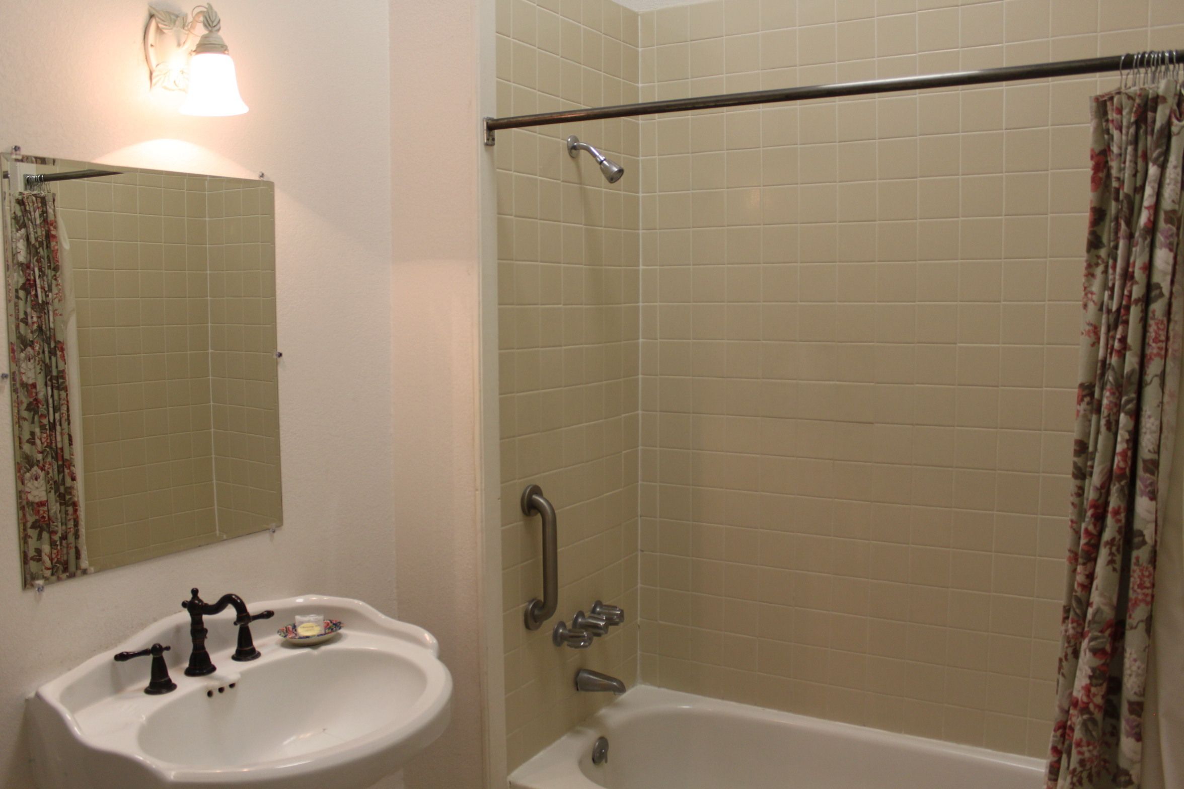 Bagno con lavandino, specchio, doccia e vasca.