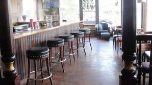 Uma área de bar com banquetas, balcão e vista para o exterior.