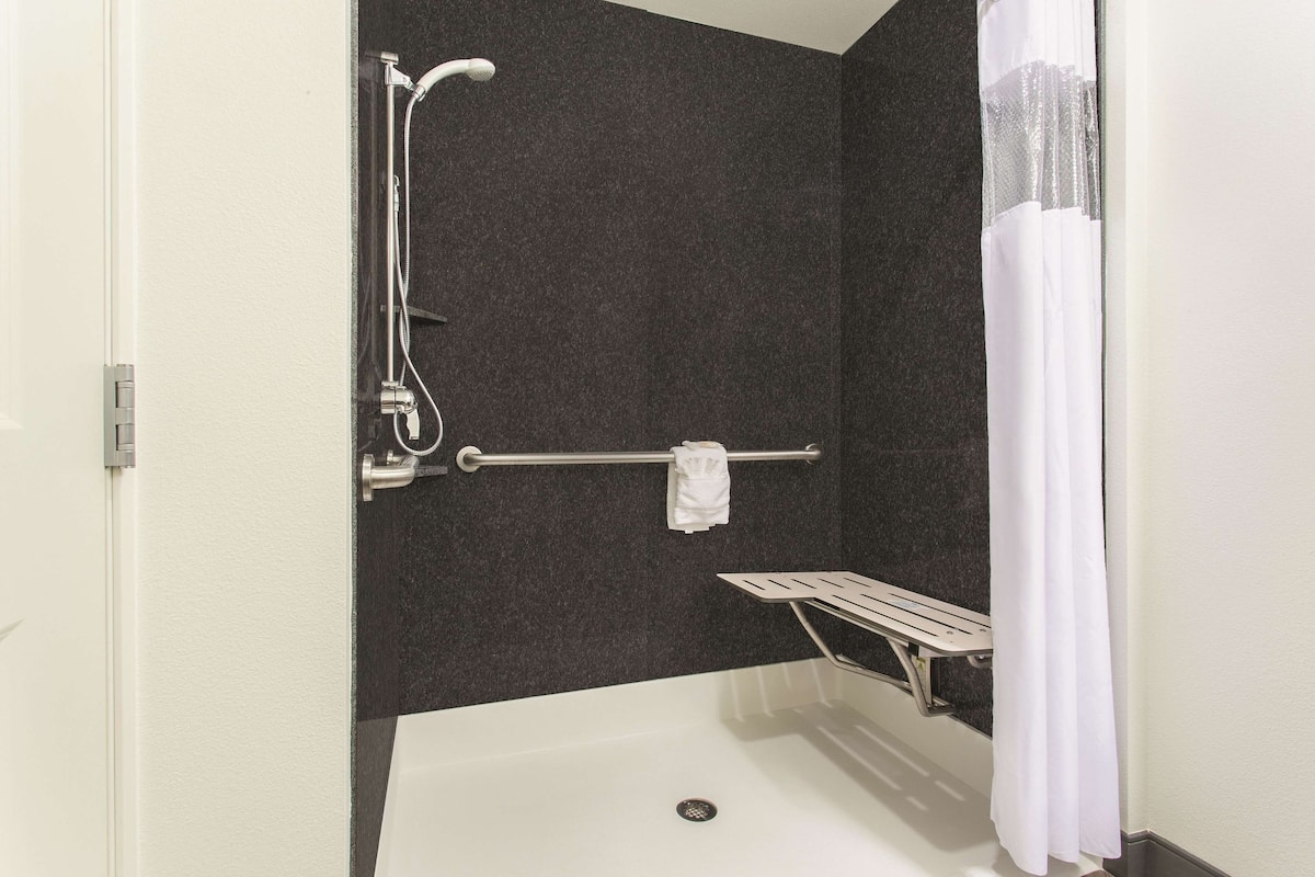 Un área de ducha con bañera, toallero y ducha.