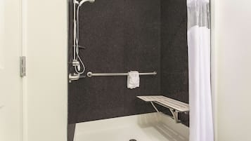 Un área de ducha con bañera, toallero y ducha.