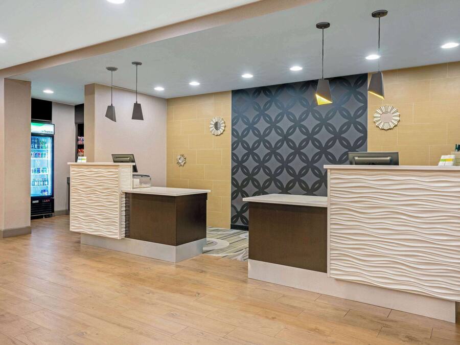 A reception area with two counters, a patterned wall, and a refrigerator in the background.