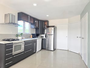 Apartamento Deluxe | Cocina privada | Frigorífico grande, microondas, placa de cocina y cafetera o tetera