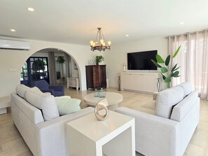 Ein modernes Wohnzimmer mit einer Couch, einem Couchtisch und einem Fernseher.