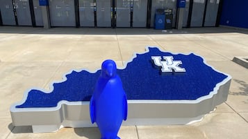 A blue sculpture of a bird on a blue carpet with the UK logo.