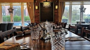 A dining area with a long table set for a meal, featuring clear glassware and silverware. - Steam Packet Inn (Totnes)