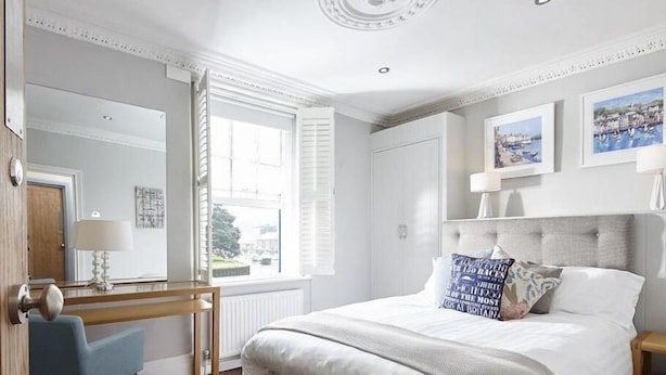 A neatly arranged bedroom with a large bed, a desk, and a window with a view. - Steam Packet Inn (Totnes)