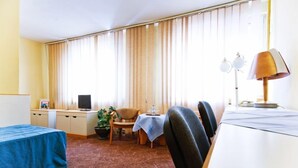 Een hotelkamer met een bed, bureau, stoel, tafel en lamp.