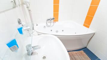 Une salle de bain équipée d’une baignoire, d’un lavabo et d’une douche à parois en verre.
