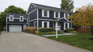 A two-story house with a garage, a front porch, and a mailbox.