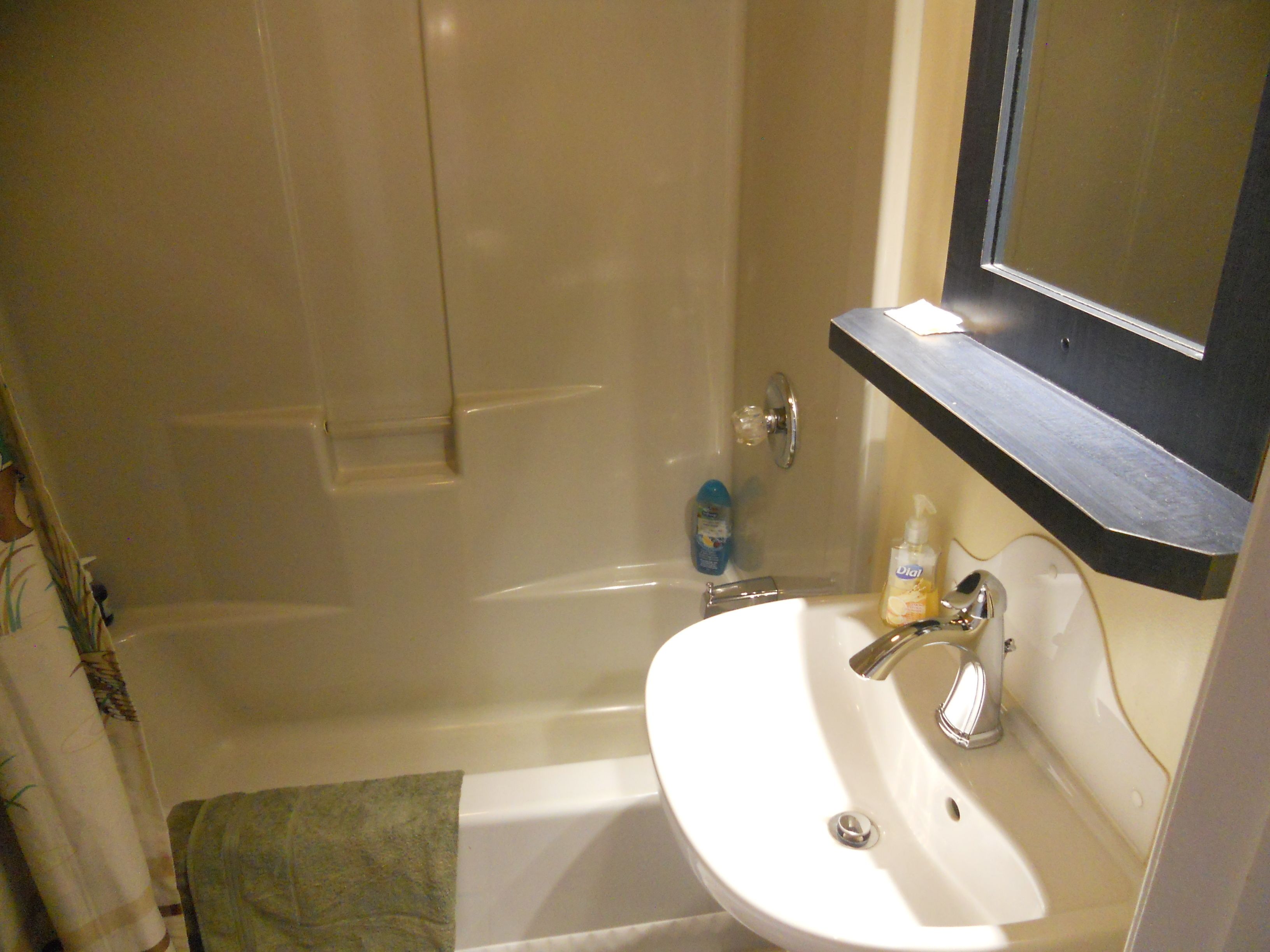 Un baño con bañera, lavamanos y espejo.