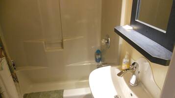 Un baño con bañera, lavamanos y espejo.
