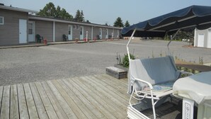 En rad motellrum med ett takförsett utomhusområde med sittplatser.