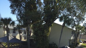 A swimming pool with a tiled deck, surrounded by a white fence and lounge chairs. - High Point World Resort (Kissimmee)