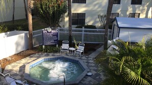 A spa area with a hot tub, white chairs, and a sign detailing spa rules. - High Point World Resort (Kissimmee)
