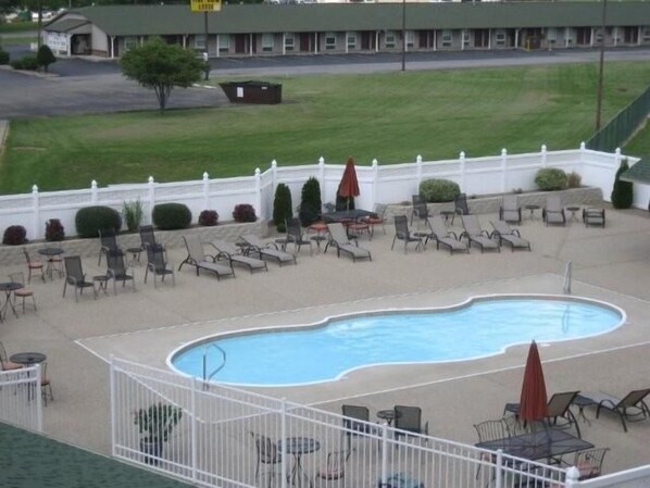 Una piscina al aire libre, sillones reclinables de piscina