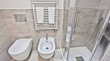 Un baño moderno con bidé, lavamanos y ducha.