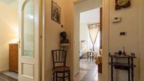 A hallway with a wooden chair, a small table, and a shelf with books. - Da Agnese Locazioni brevi (Cagliari)