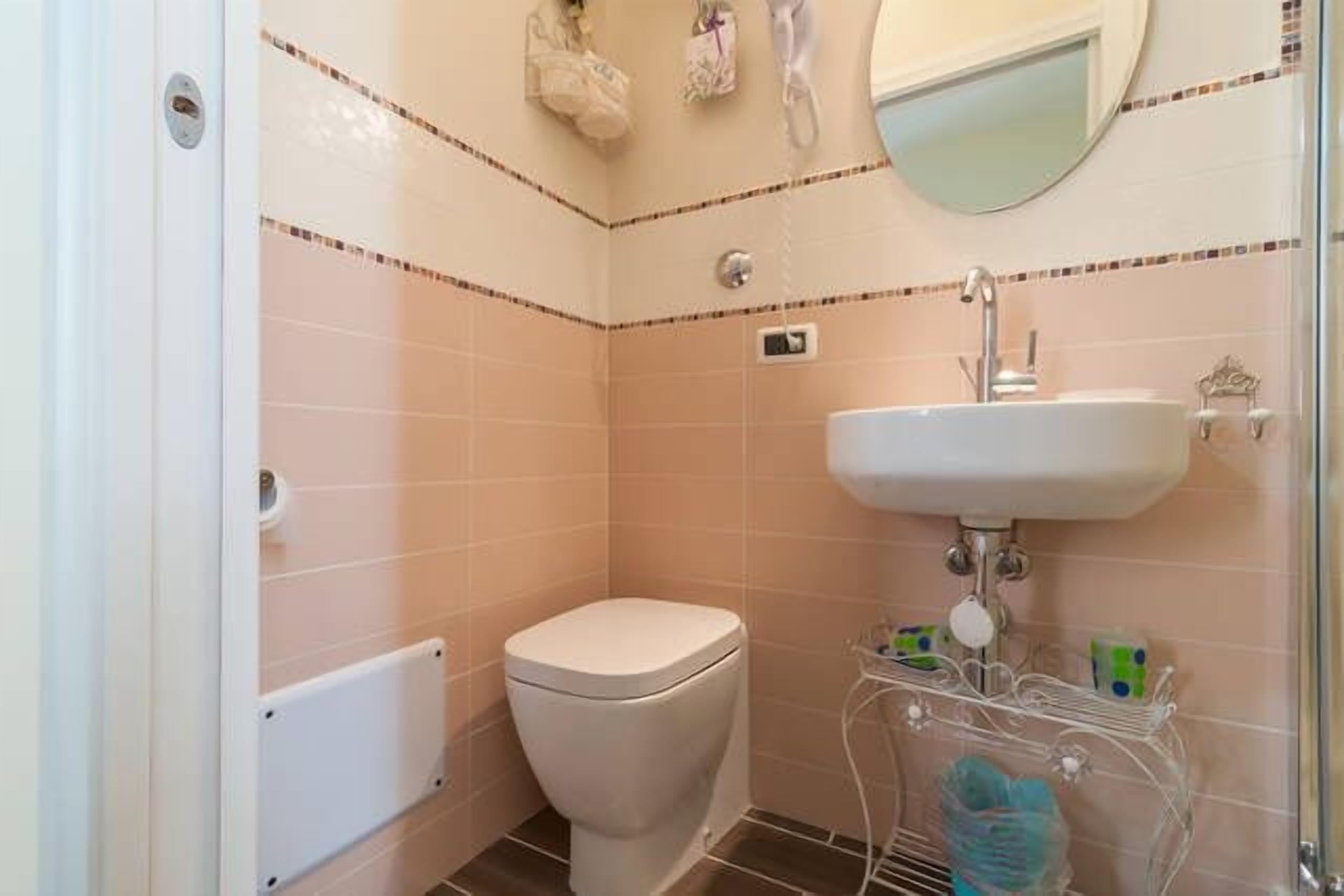 Un bagno piccolo con il water, un lavandino e una doccia.