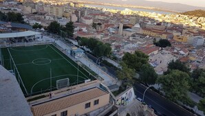 A cityscape with a prominent soccer field, buildings, and a distant body of water. - Da Agnese Locazioni brevi (Cagliari)