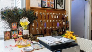 A desk with religious icons, peacock feathers, and a calculator. - Budget Inn Jennings LA I-10 (Jennings)