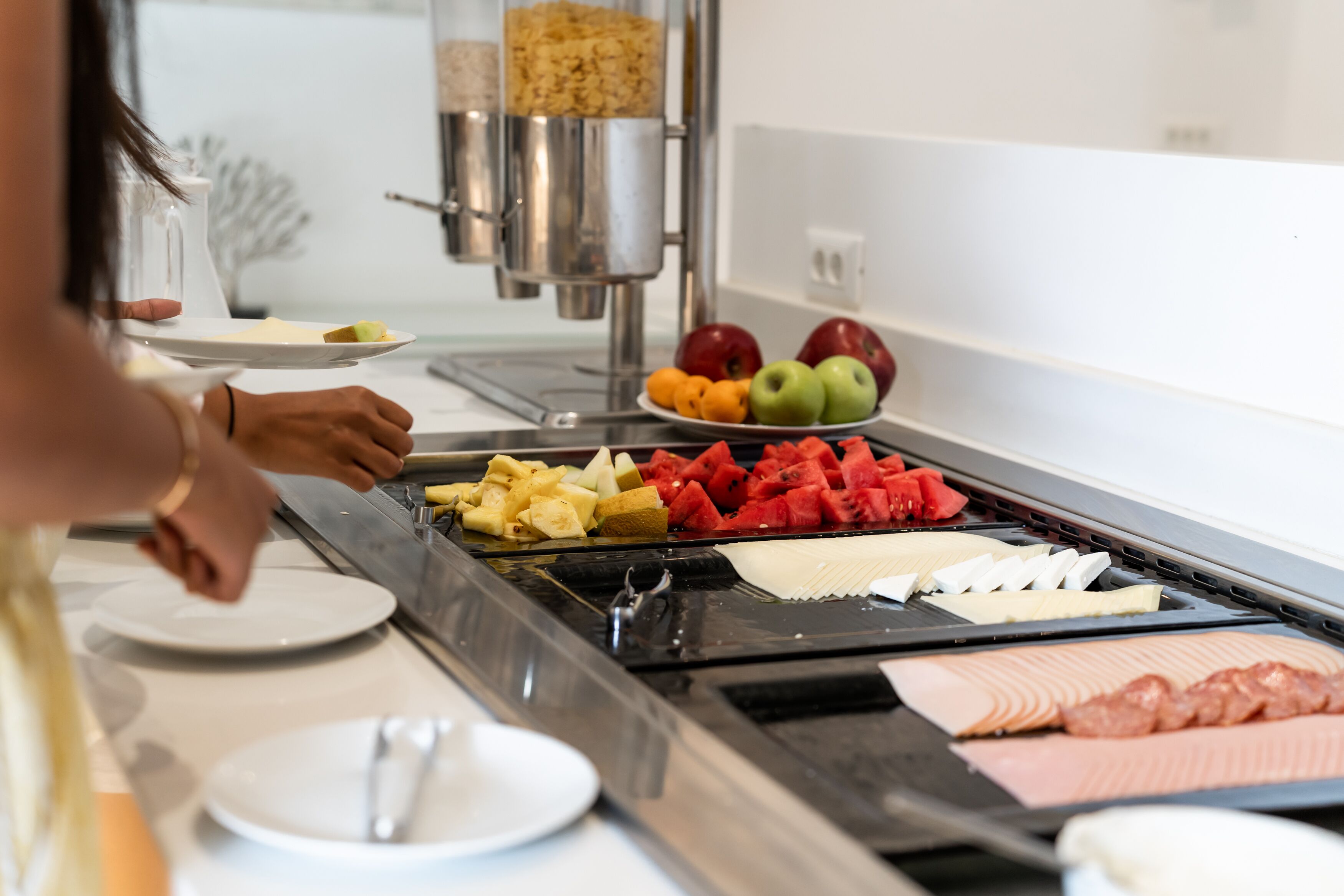 Un bufé con diversos alimentos, incluyendo frutas, verduras y carnes.