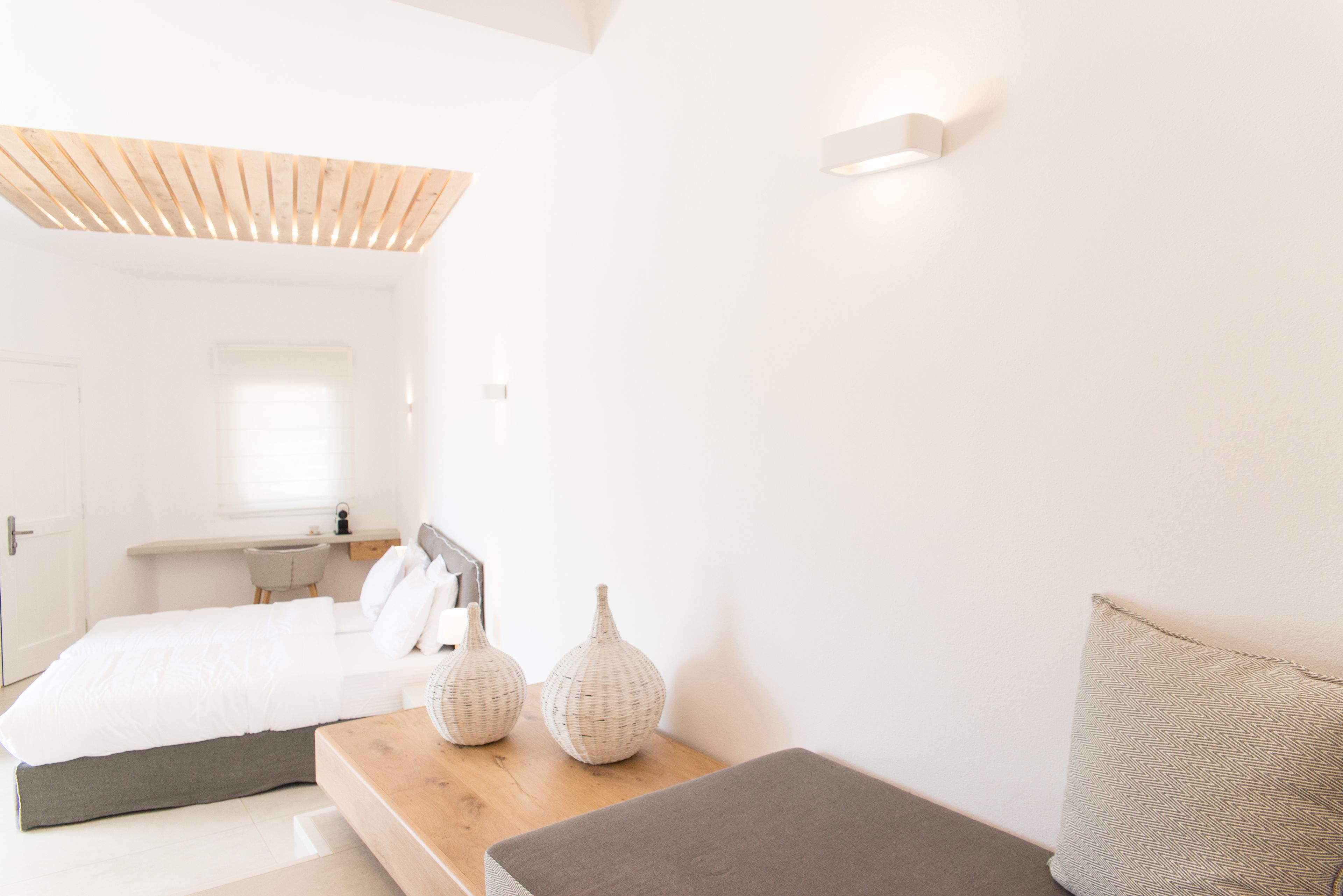 A modern bedroom with a bed, bedside tables, and decorative vases.