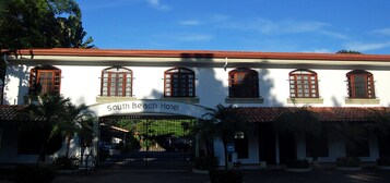 The South Beach Hotel entrance with a red-tiled roof, arched windows, and a sign above the entrance.