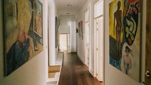 A hallway with wooden flooring and walls adorned with abstract paintings. - Asul B&B (Lisbon)