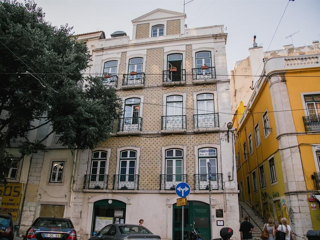 A multi-story building with a traditional facade, a visible ground floor entrance, and a staircase leading to the upper floors. - Asul B&B (Lisbon)