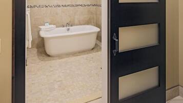 A bathroom with a bathtub, a towel rack, and a sliding door.