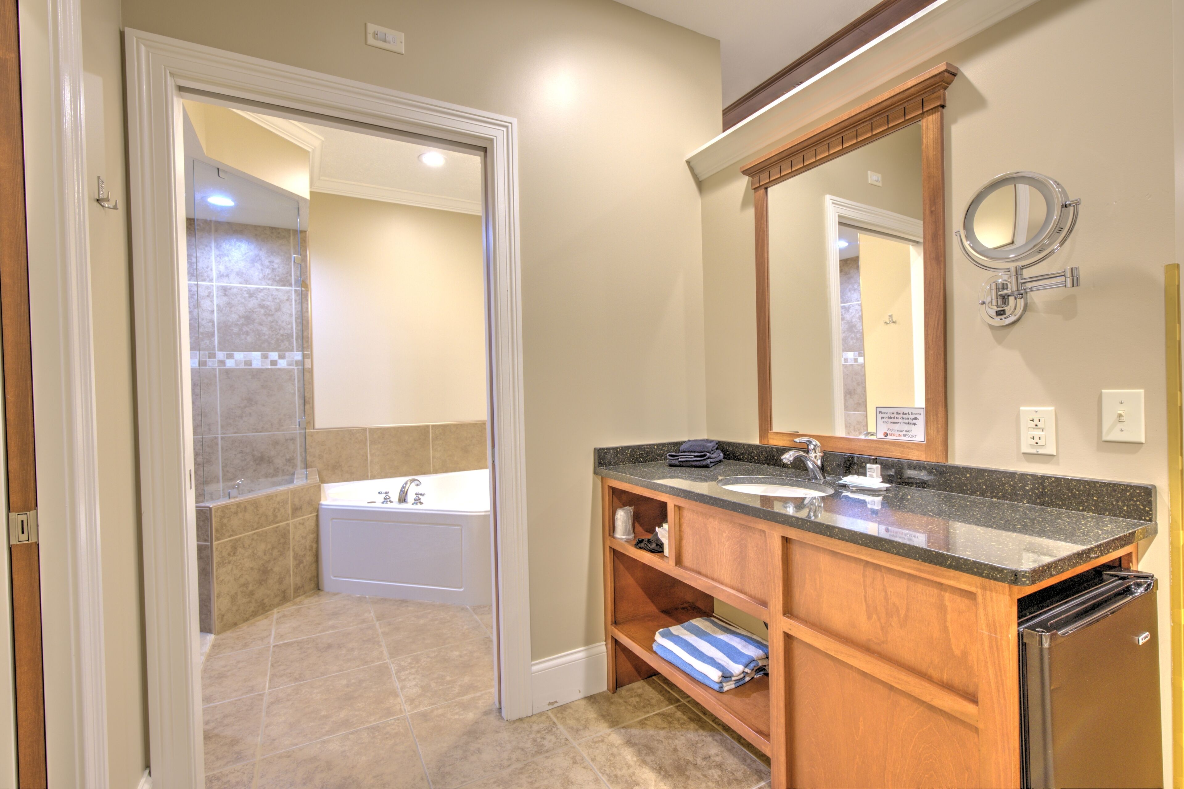 A bathroom with a double sink, a mirror, and a shower.